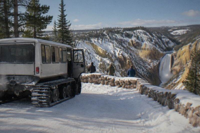 Snowcoach parked on a snow-covered road in the Grand Canyon of the Yellowstone in winter