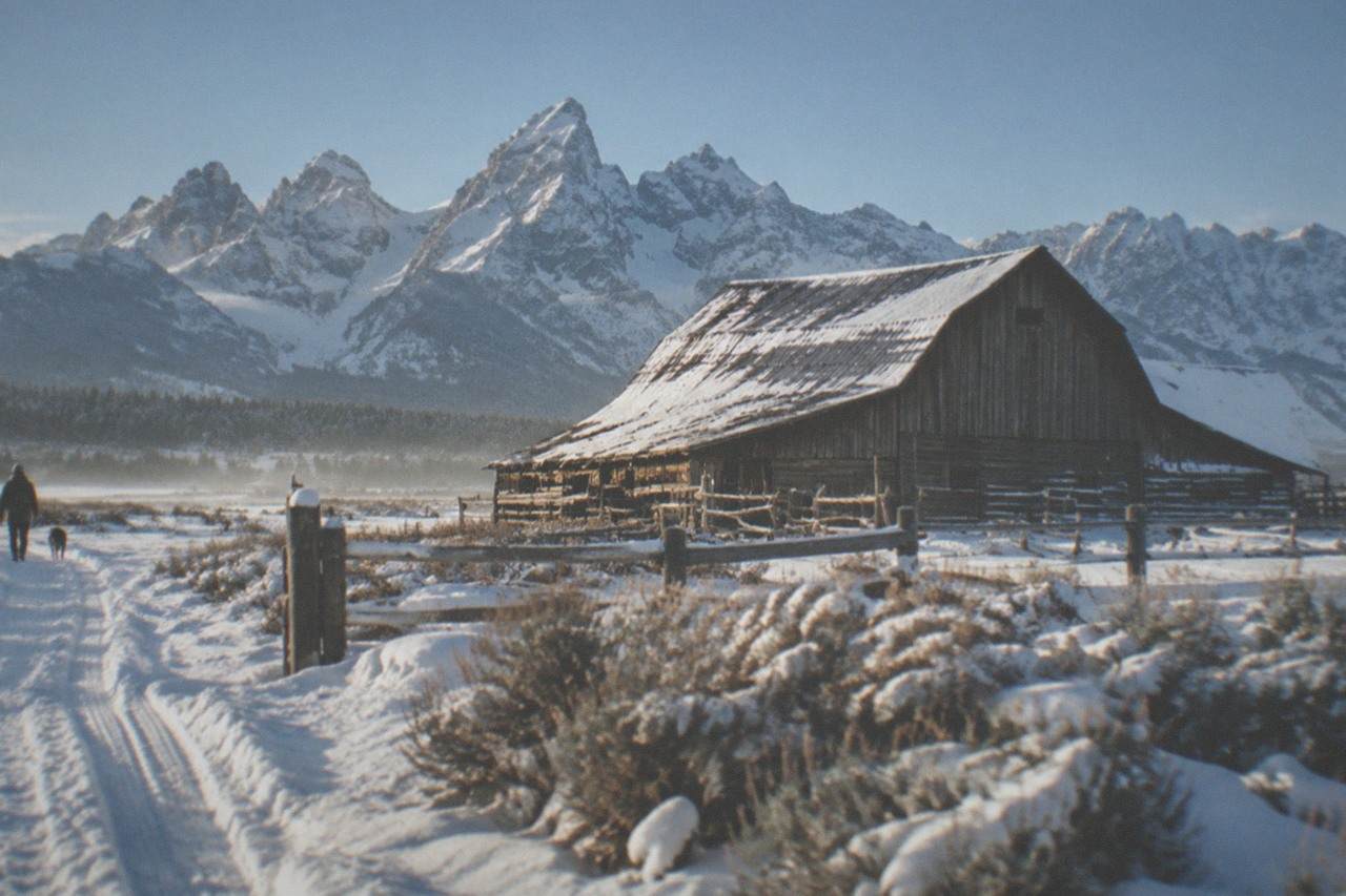 Snow-covered valley with mountain peaks under a clear winter sky in the Jackson Hole area