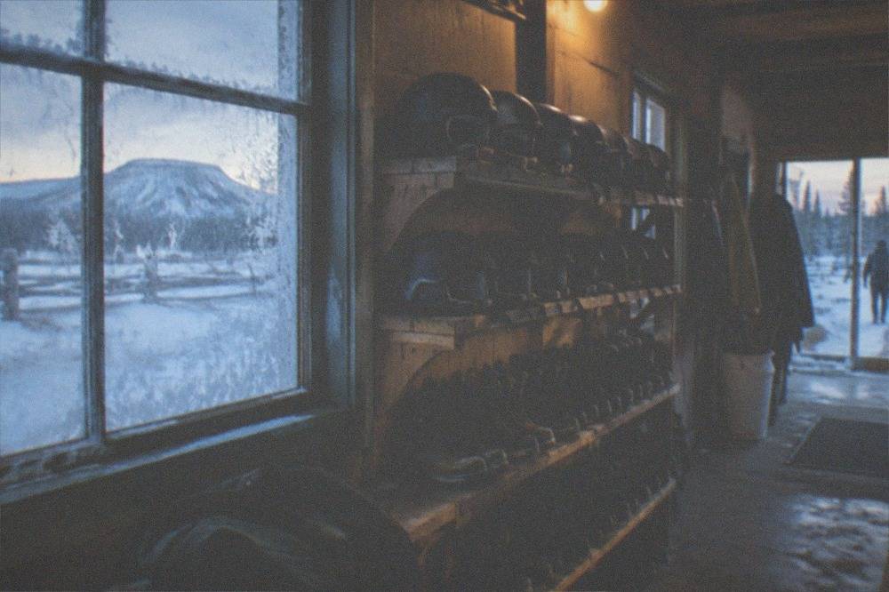 Snowmobile helmets and insulated boots lined up on shelves in a tour outfitting room