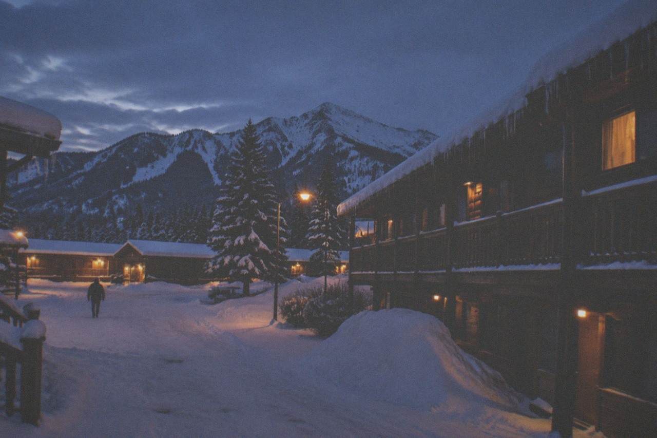 Snow-covered motel buildings and street lights in a small winter town at dusk
