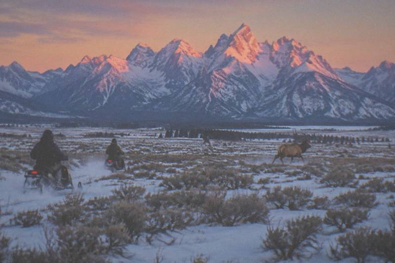 Snowmobiles with the snow-capped Grand Teton range in the background