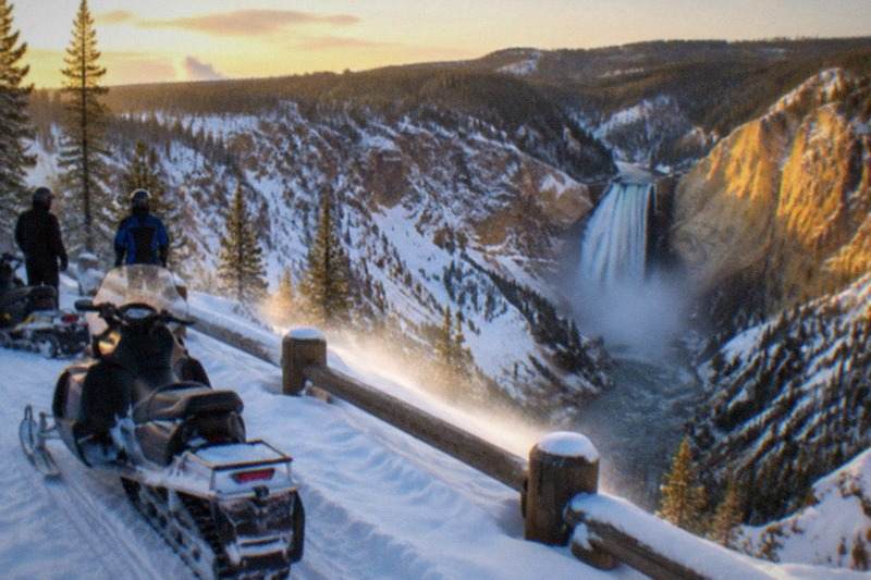 Snowmobiles overlooking the snow-covered Grand Canyon of the Yellowstone